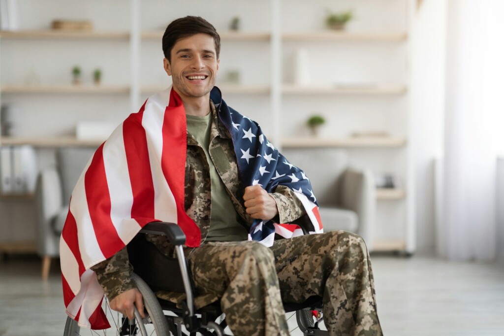 Cheerful military guy in wheelchair with flag of the US