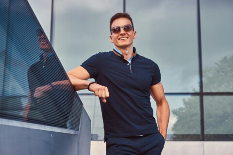 Fashionable man dressed in a black t-shirt and pants, standing in the modern city