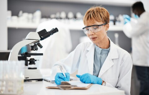 Scientist, woman and writing lab report with results, focus or analysis for pharma development. Sci