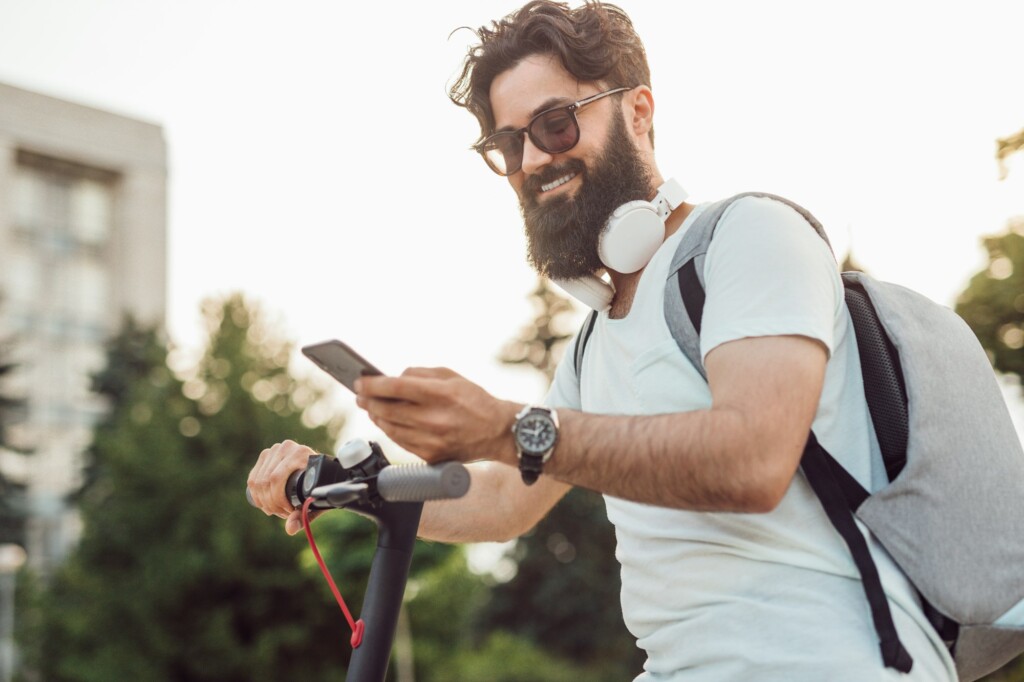Smiling hipster using modern gadgets in everyday life